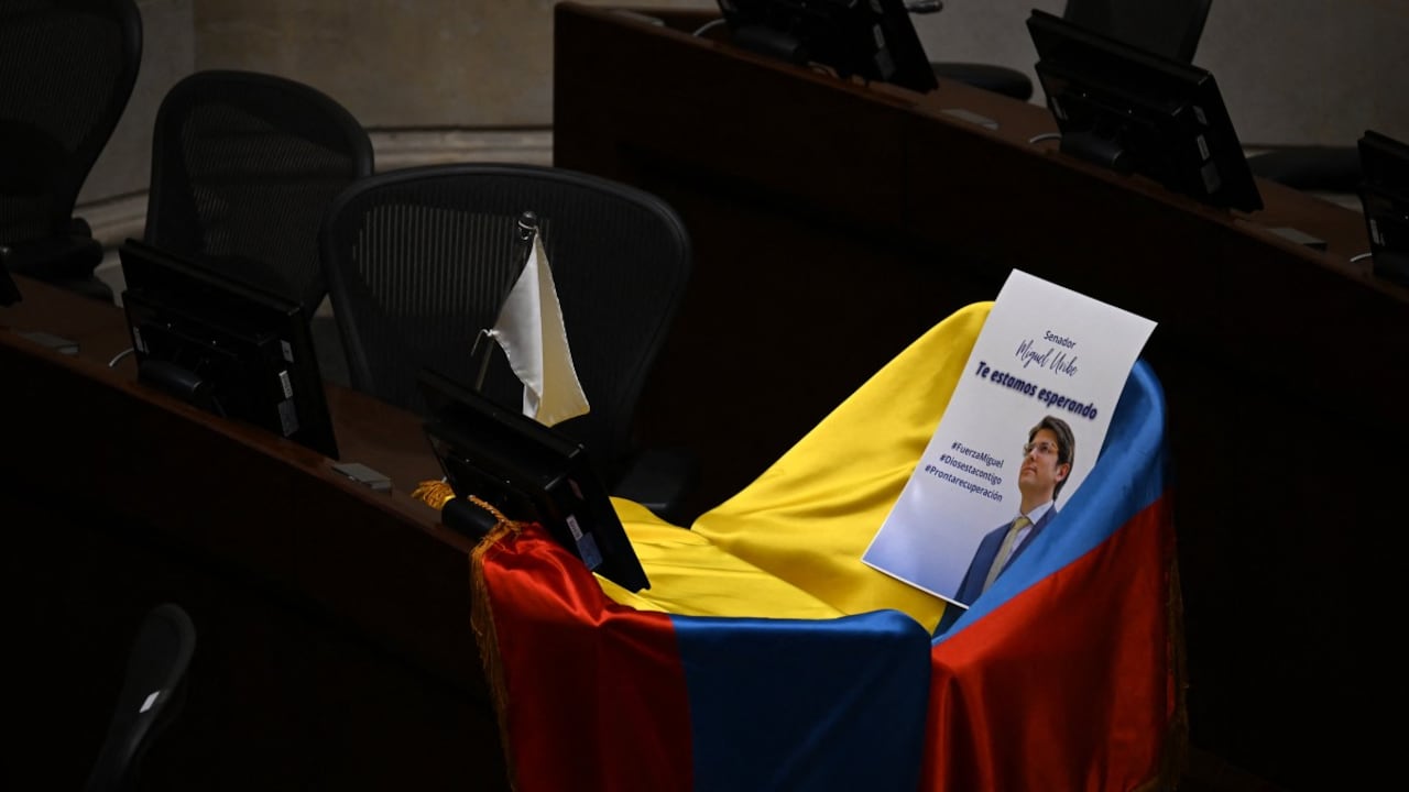 Una foto del senador y candidato presidencial colombiano Miguel Uribe con la frase "Te estamos esperando" sobre una bandera colombiana se ve encima de su asiento en el Congreso, en Bogotá, el 9 de junio de 2025.