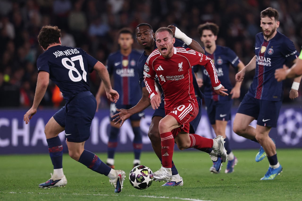 El centrocampista argentino del Liverpool, Alexis Mac Allister (C), número 10, cae al suelo tras ser placado durante el partido de ida de los cuartos de final de la Liga de Campeones de la UEFA entre el Paris Saint-Germain (PSG) y el Liverpool FC en el estadio Parc des Princes de París, el 8 de abril de 2026. (Foto de FRANCK FIFE / AFP)