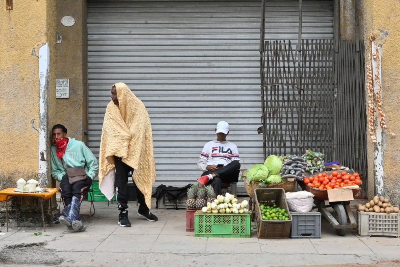 Vendedores ambulantes abrigados trabajan en una calle de La Habana, país que entra en crisis por la falta de petróleo.