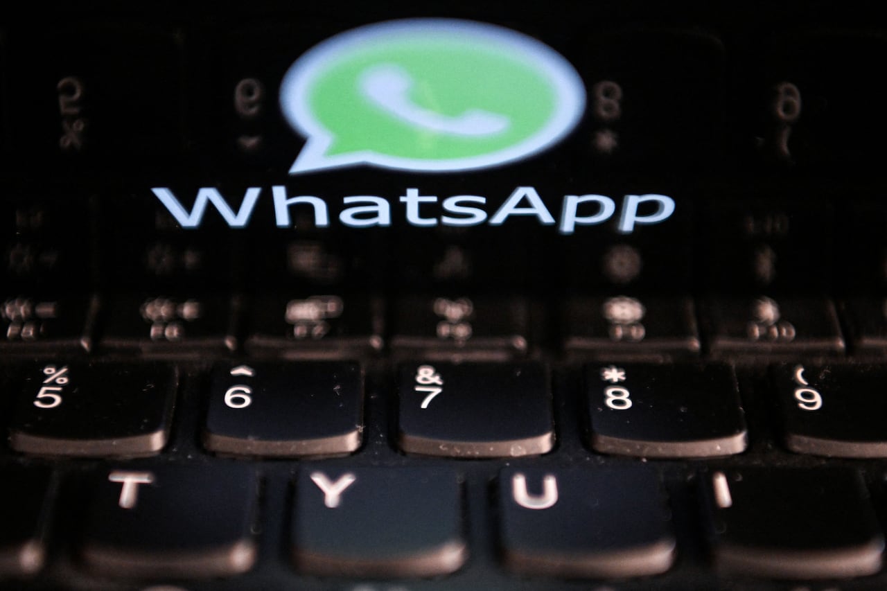 This photo illustration shows a woman checking the settings of the messaging application WhatsApp