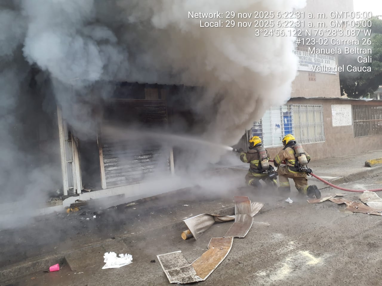 Bomberos apagando el incendio de una edificación en el barrio Calimio Decepaz del oriente de Cali.