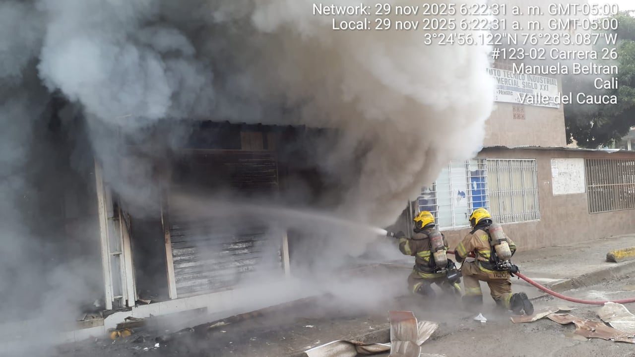 Bomberos apagando el incendio de una edificación en el barrio Calimio Decepaz del oriente de Cali.