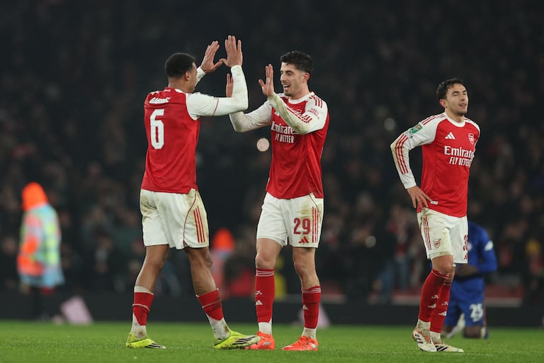 El centrocampista alemán del Arsenal, Kai Havertz (centro), celebra con el defensa brasileño del Arsenal, Gabriel Magalhaes (izq.), tras el partido de vuelta de las semifinales de la Copa de la Liga inglesa entre el Arsenal y el Chelsea en el Emirates Stadium de Londres el 3 de febrero de 2026. El Arsenal ganó el partido por 1-0 y la eliminatoria por 4-2 en el global. (Foto de Adrian Dennis / AFP)
