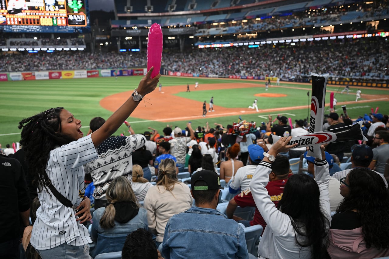 Aficionados animan durante el partido de béisbol entre Navegantes del Magallanes y Leones del Caracas en el Estadio Monumental Simón Bolívar de Caracas, el 21 de diciembre de 2025. (Foto de Federico PARRA / AFP)