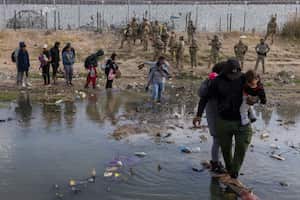 La Guardia Nacional de Texas lleva a cabo una operación utilizando armas no letales, específicamente una pistola de gas pimienta, para dispersar a los migrantes que mantienen un campamento dentro del Río Grande, en la frontera entre México y Estados Unidos, en Ciudad Juárez, México, el 20 de abril de 2024. (Foto de David Peinado/Anadolu vía Getty Images)