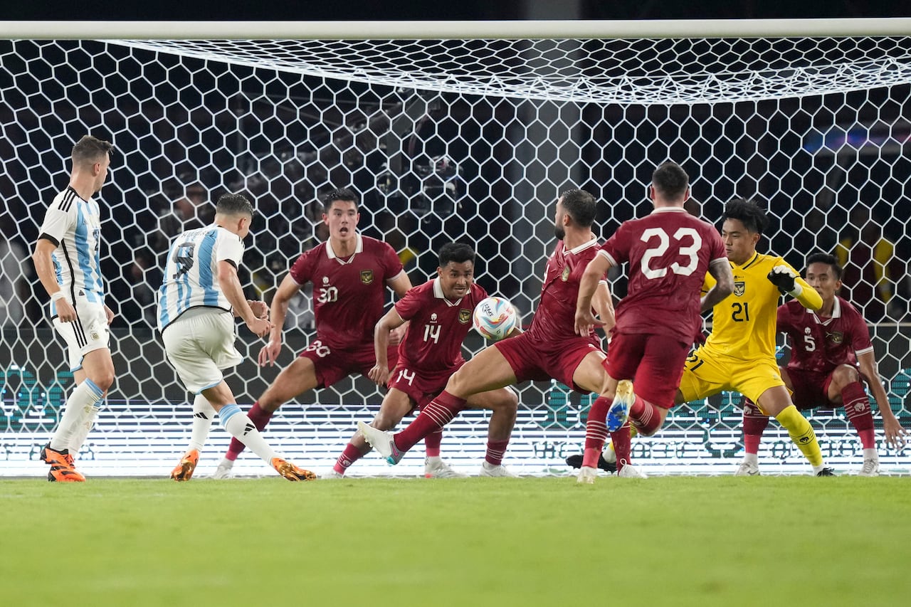 Julian Alvarez de Argentina, segundo a la izquierda, dispara al arco mientras Asnawi Mangkualam, de 14 años, y Elkan Baggott, de 30, de Indonesia, reaccionan durante su partido amistoso de fútbol en el Estadio Principal Gelora Bung Karno en Yakarta, Indonesia, el lunes 19 de junio de 2023. (AP Foto/Tatán Syuflana)