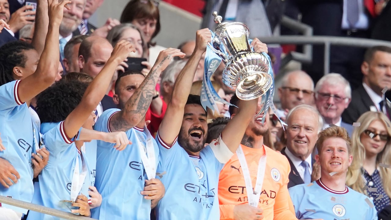 Ilkay Gundogan, del Manchester City, en el centro, sostiene el trofeo de los ganadores mientras celebra con sus compañeros ganar la final de la Copa FA inglesa entre el Manchester City y el Manchester United en el estadio de Wembley en Londres, el sábado 3 de junio de 2023. El Manchester City ganó 2-1 . (Foto AP/Dave Thompson)