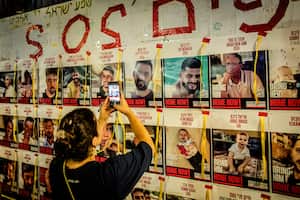 Una mujer israelí fotografía un cartel cubierto con imágenes de rehenes retenidos por Hamas en Gaza durante una manifestación que conmemora los 300 días desde el 7 de octubre. Mientras Israel se prepara para posibles represalias de Irán y Hezbolá tras los asesinatos del líder de Hamás, Ismail Haniyah en Teherán, y del alto comandante de Hezbolá, Fuad Shukr en Beirut, las familias de los rehenes israelíes retenidos por Hamás en Gaza conmemoran el día 300 desde la masacre del 7 de octubre