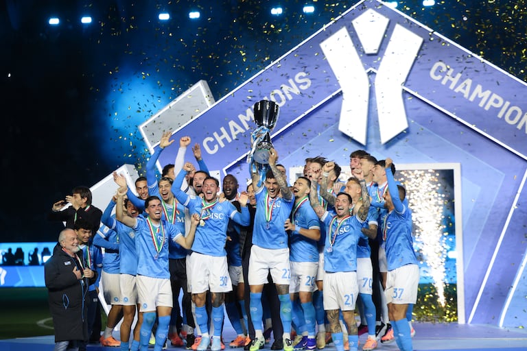 El defensa italiano número 22 del Napoli, Giovanni Di Lorenzo, levanta el trofeo en el podio tras la final de la Supercopa de Italia entre el SCC Napoli y el Bolonia en el estadio King Al-Awwal Park de Riad, el 22 de diciembre de 2025. (Foto de Fayez NURELDINE / AFP)