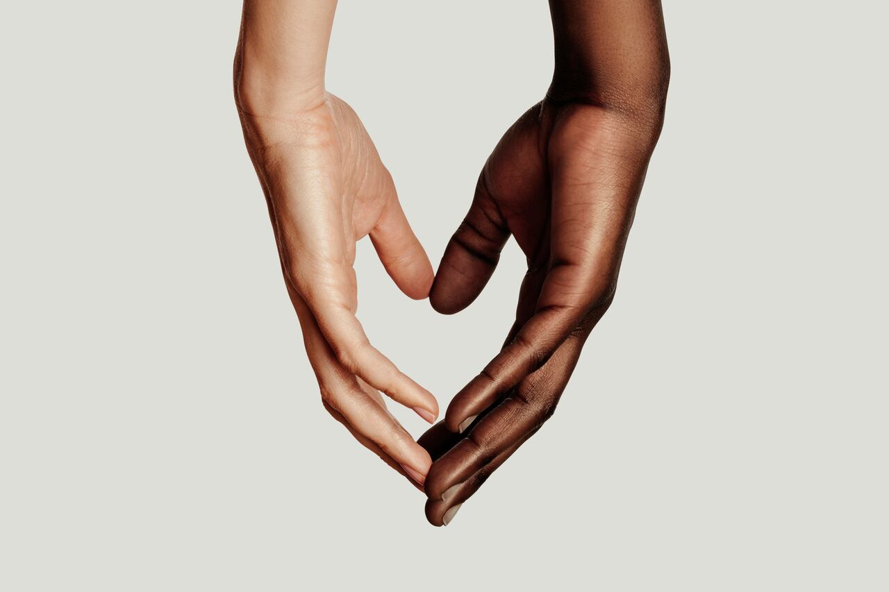 two hands coming together, creating a heart shape