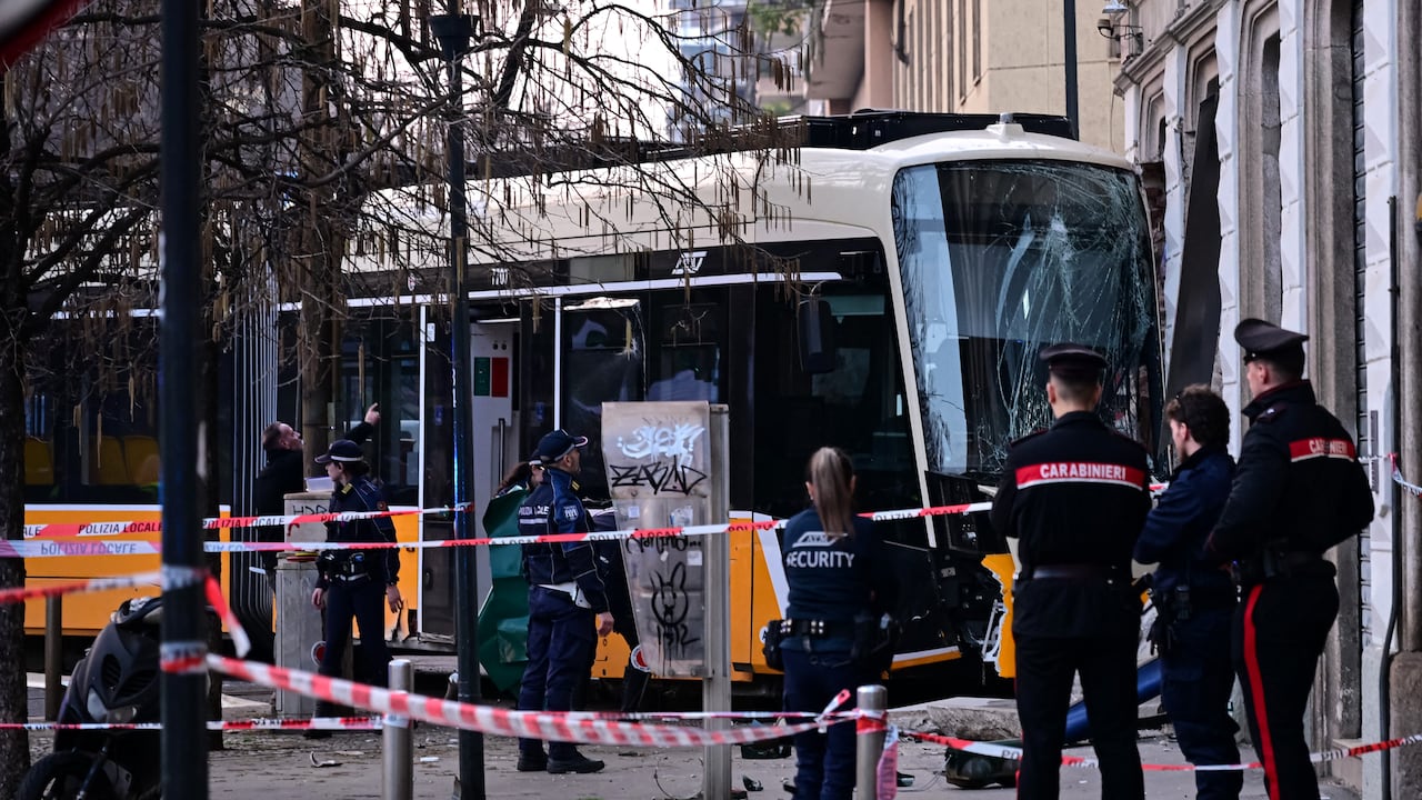 Agentes de la policía italiana en el lugar del descarrilamiento de un tranvía en Milán el 27 de febrero de 2026. Un tranvía descarriló y se estrelló contra un edificio en Milán el 27 de febrero de 2026, dejando una persona muerta y una veintena de heridos, según informó la policía a AFP. (Foto de Piero CRUCIATTI / AFP)