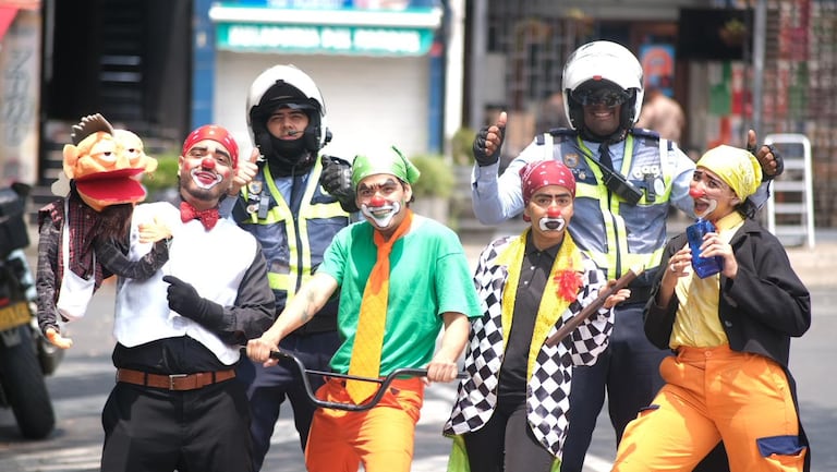 Artistas caracterizados y agentes de tránsito interactúan con ciudadanos durante una intervención pedagógica de la campaña ‘Pensala Vé’, que llevó mensajes de cultura vial y respeto por la vida a las calles de Cali.