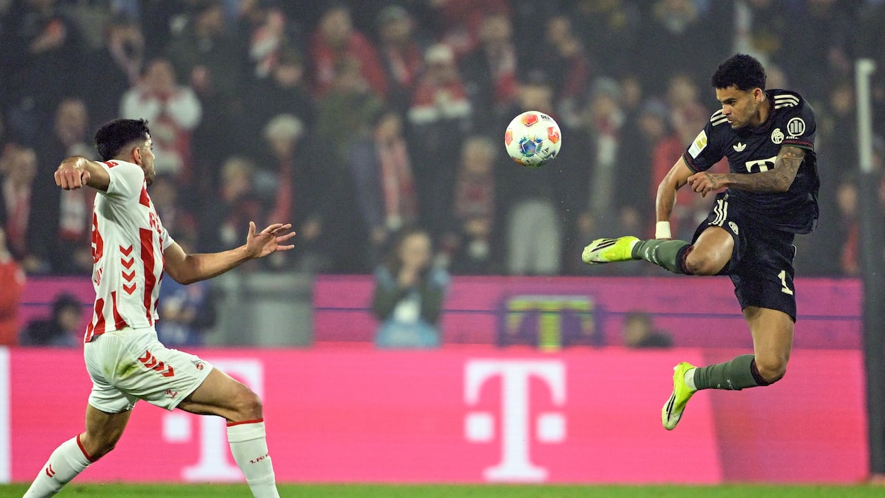 El delantero colombiano #14 del Bayern Múnich, Luis Díaz (der.), salta por el balón durante el partido de la Bundesliga alemana entre el FC Colonia y el FC Bayern Múnich en Colonia, Alemania, el 14 de enero de 2026. (Foto de INA FASSBENDER / AFP)