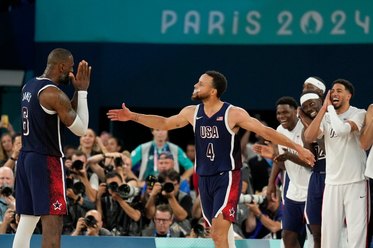 Los estadounidenses Stephen Curry (4) y LeBron James (6) celebran después de vencer a Francia para ganar la medalla de oro durante un partido de baloncesto masculino por la medalla de oro en el Bercy Arena en los Juegos Olímpicos de Verano de 2024, el sábado 10 de agosto de 2024, en París, Francia. (Foto AP/Mark J. Terrill)