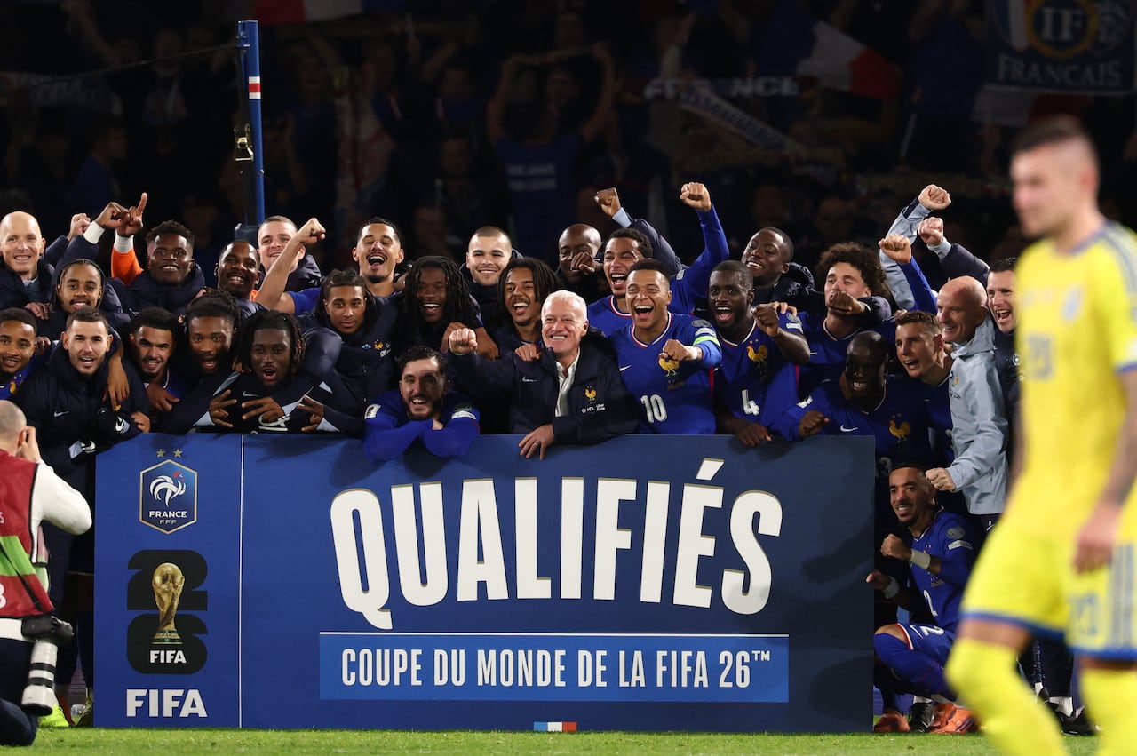 El seleccionador francés, Didier Deschamps (C), junto al delantero número 10, Kylian Mbappé (C-D), celebra con sus compañeros y el cuerpo técnico la victoria de Francia sobre Ucrania en el partido de clasificación para el Mundial de 2026, correspondiente al Grupo D de la zona europea, disputado en el estadio Parc des Princes de París el 13 de noviembre de 2025. Francia venció a Ucrania por 4-0 y se clasificó para el Mundial de 2026. (Foto: FRANCK FIFE / AFP)