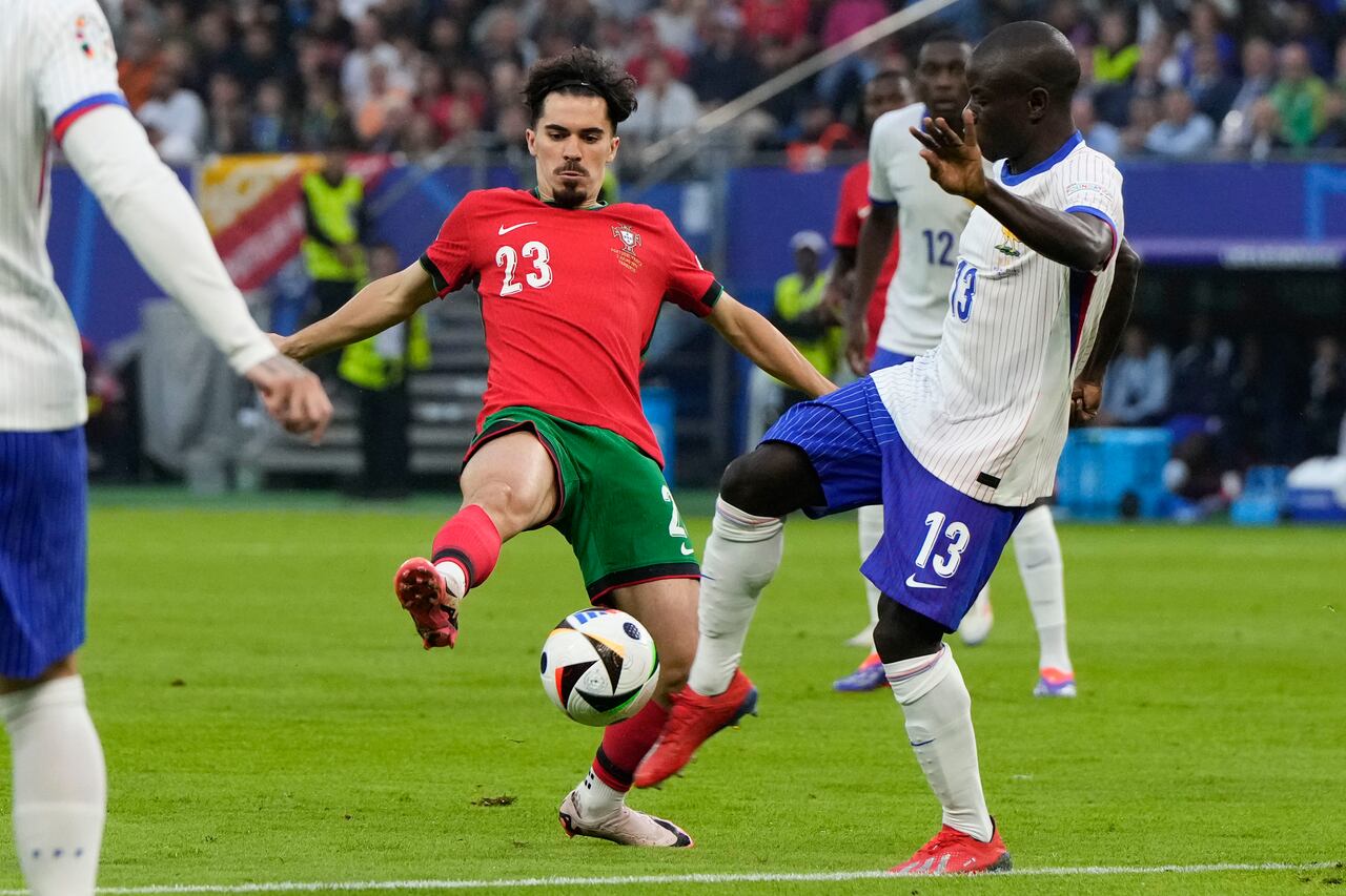 Vitinha de Portugal, izquierda, y N'Golo Kante de Francia luchan por el balón durante un partido de cuartos de final del torneo de fútbol Euro 2024 en Hamburgo, Alemania, el viernes 5 de julio de 2024. (Foto AP/Hassan Ammar)