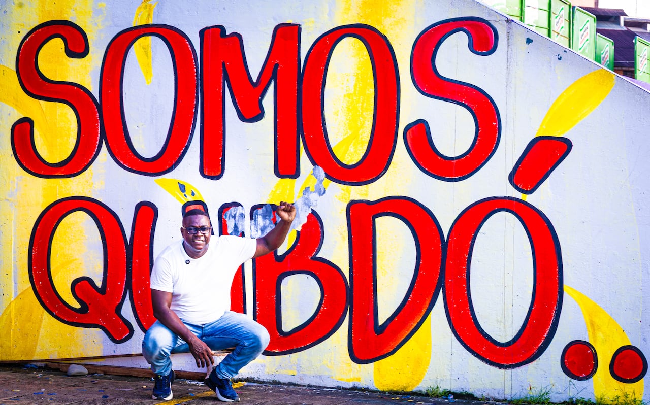 Benildo Estupiñán frente a un mural urbano que alude a la identidad cultural de Quibdó.