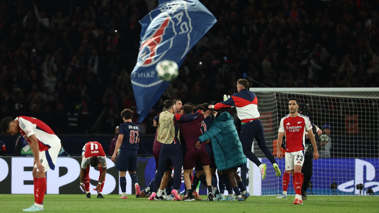 Los jugadores del Arsenal reaccionan mientras los jugadores del PSG celebran su victoria al final del partido de vuelta de la semifinal de la UEFA Champions League.