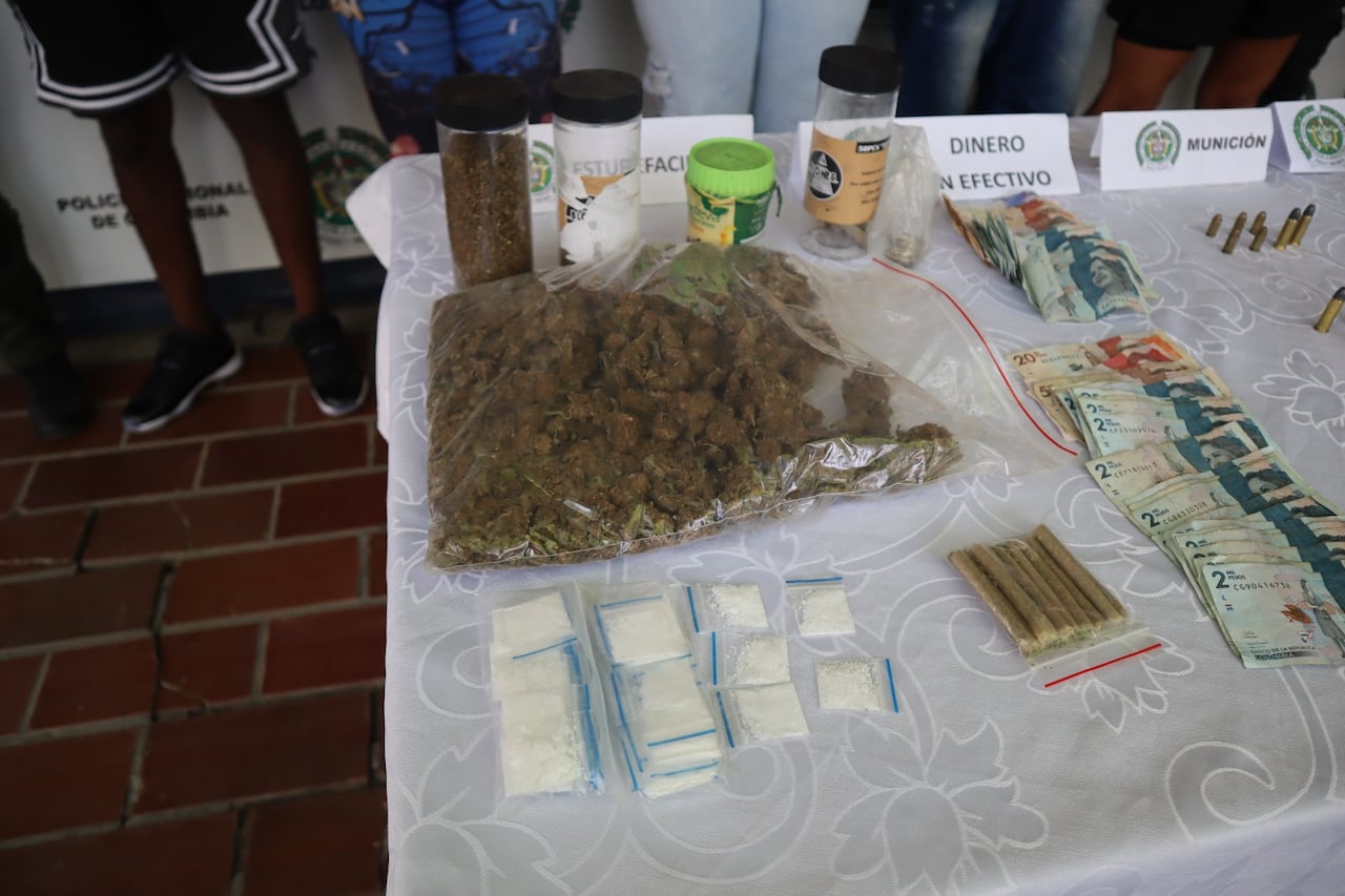 Las cuatro armas de fuego, municiones, dinero en efectivo y estupefacientes incautados por las autoridades durante los operativos en la Comuna 16.
