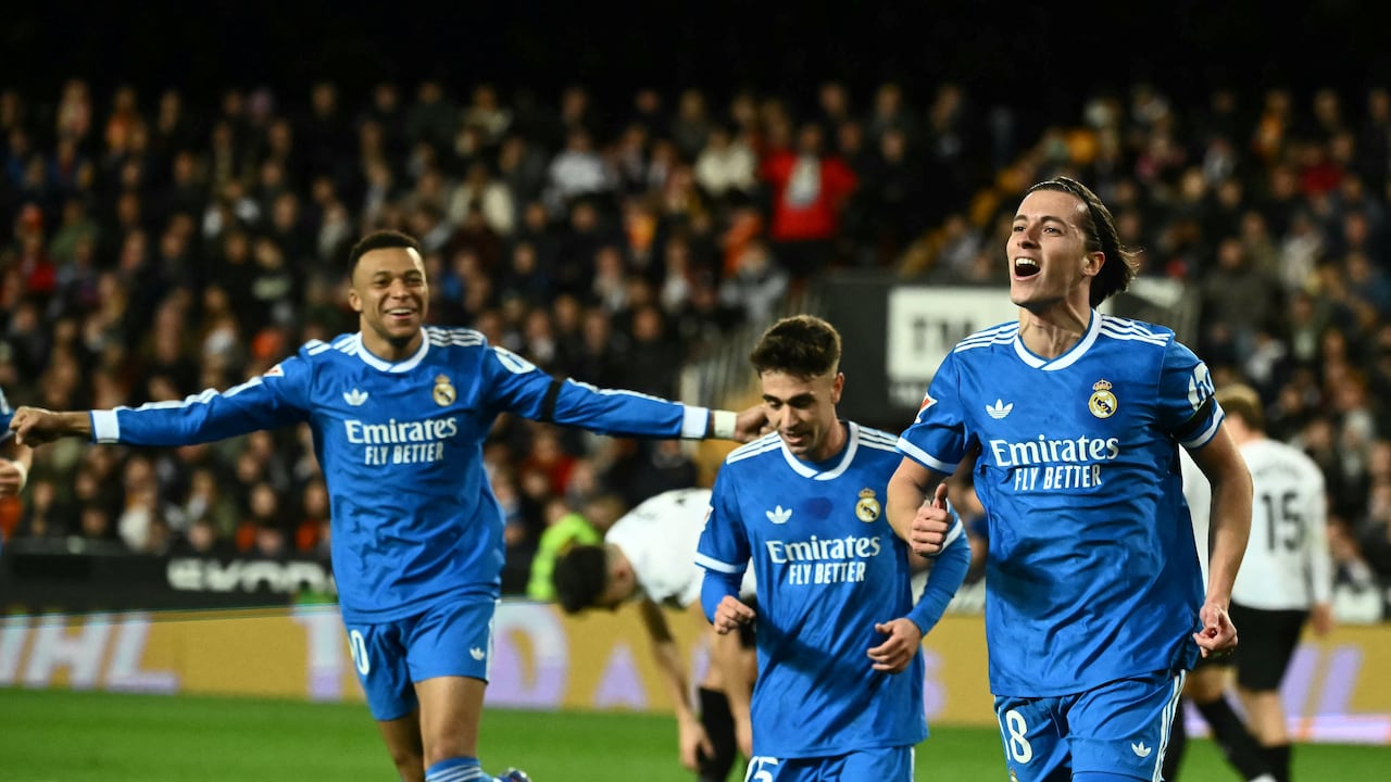 El defensa español #18 del Real Madrid, Álvaro Carreras, celebra con el delantero francés #10 del Real Madrid, Kylian Mbappé (izq.), el primer gol de su equipo durante el partido de la liga española entre el Valencia CF y el Real Madrid CF en el Estadio Mestalla en Valencia el 8 de febrero de 2026. (Foto de JOSE JORDAN / AFP)