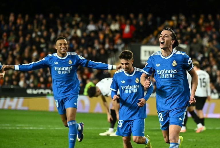El defensa español #18 del Real Madrid, Álvaro Carreras, celebra con el delantero francés #10 del Real Madrid, Kylian Mbappé (izq.), el primer gol de su equipo durante el partido de la liga española entre el Valencia CF y el Real Madrid CF en el Estadio Mestalla en Valencia el 8 de febrero de 2026. (Foto de JOSE JORDAN / AFP)