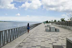 Turista paseando por el malecón y el río Magdalena. Barranquilla, Colombia