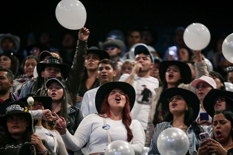 El público corea canciones y levanta pancartas en memoria del cantante durante el homenaje.