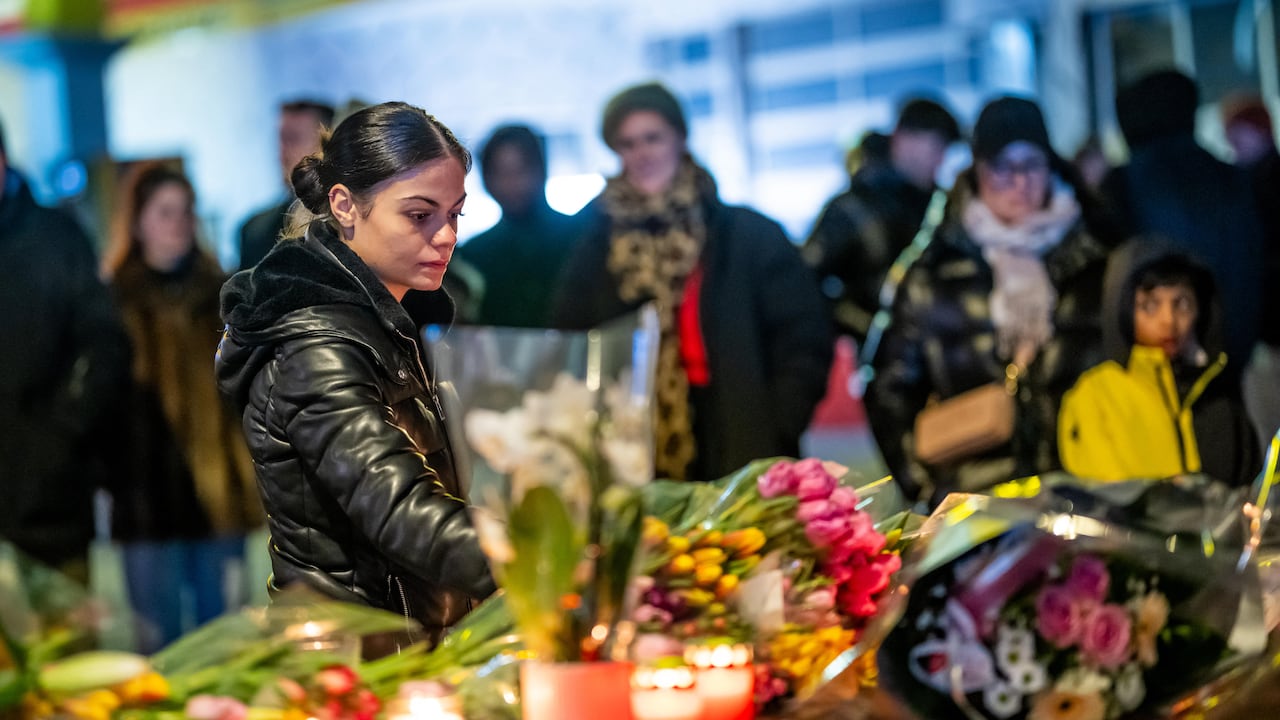 A woman lays flowers near the site where a fire ripped through a crowded bar during New Year's Eve celebrations in the Alpine ski resort town of Crans-Montana on January 1, 2026. Several dozen people are presumed dead and around 100 injured after a fire ripped through a crowded bar in the luxury Swiss ski resort of Crans-Montana, Swiss police said on January 1, 2026. Police, firefighters and rescuers rushed to the popular resort, which is set to host the Ski World Cup from January 30, after the fire broke out in the early hours of New Year's Day. (Photo by MAXIME SCHMID / AFP)