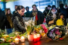 A woman lays flowers near the site where a fire ripped through a crowded bar during New Year's Eve celebrations in the Alpine ski resort town of Crans-Montana on January 1, 2026. Several dozen people are presumed dead and around 100 injured after a fire ripped through a crowded bar in the luxury Swiss ski resort of Crans-Montana, Swiss police said on January 1, 2026. Police, firefighters and rescuers rushed to the popular resort, which is set to host the Ski World Cup from January 30, after the fire broke out in the early hours of New Year's Day. (Photo by MAXIME SCHMID / AFP)