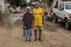 Hilario Reynosa and his wife Elodia Reyes, who survived the flooding in the Morelos neighborhood after being trapped by the overflowing Cazones River, pose for a portrait on a street covered by debris in Poza Rica, Veracruz state, Mexico on October 15, 2025. Clinging to one another and to life itself as floodwater engulfed their house last week, Reynosa and Reyes, an elderly Mexican couple became a symbol of hope as video of their desperate struggle for survival went viral. (Photo by Marco Antonio Perez / AFP)