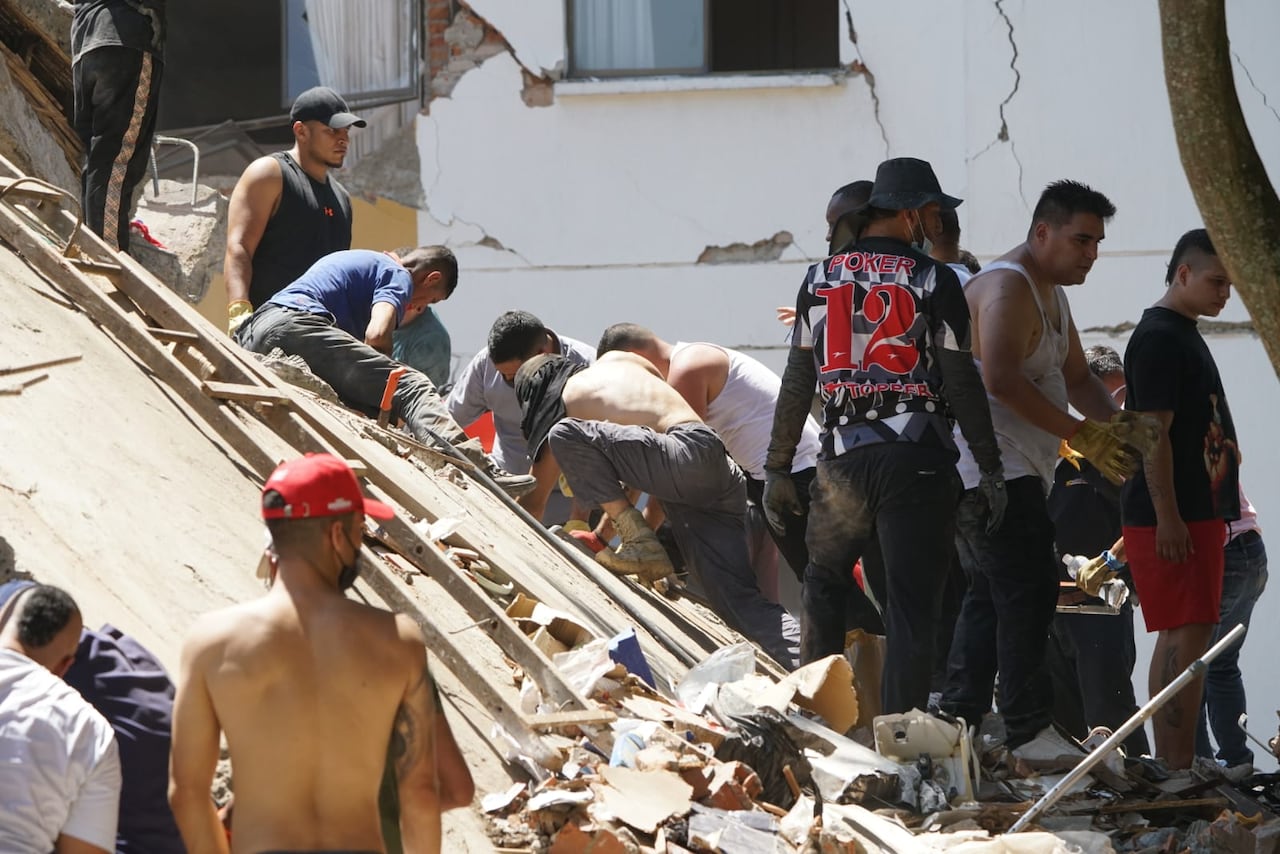 Equipos de emergencia y ciudadanos participan en las labores de atención tras los daños registrados en Cali por el fuerte sismo.