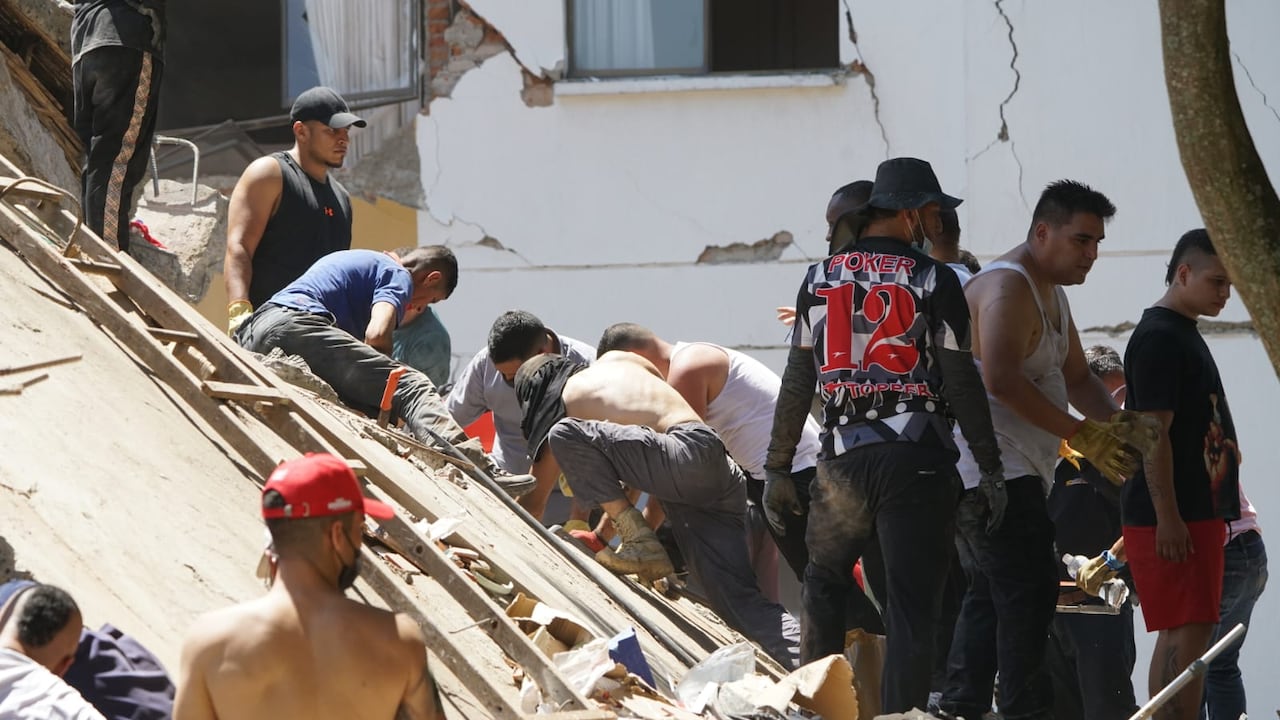 Equipos de emergencia y ciudadanos participan en las labores de atención tras los daños registrados en Cali por el fuerte sismo.
