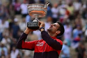 El serbio Novak Djokovic levanta su trofeo mientras celebra su victoria sobre el noruego Casper Ruud durante el partido final individual masculino del día quince del torneo de tenis Roland-Garros Open en la Court Philippe-Chatrier de París el 11 de junio de 2023. (Photo by JULIEN DE ROSA / AFP)