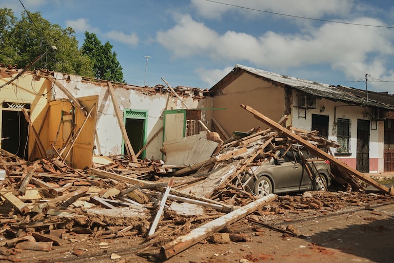 Un automóvil aparece cubierto de escombros de casas dañadas por un terremoto en Villa de los Santos, Panamá.