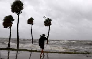 La gente camina bajo el viento y la lluvia junto a la Bahía de Tampa mientras el huracán Helene azota la costa el 26 de septiembre de 2024, en San Petersburgo, Florida.