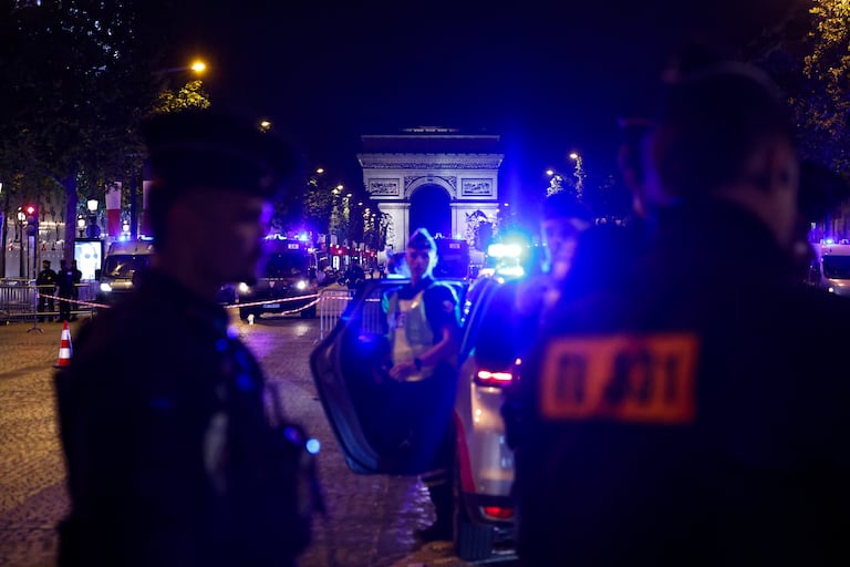 Agentes de policía bloquean los Campos Elíseos tras el partido de vuelta de las semifinales de la Liga de Campeones de la UEFA entre el Bayern de Múnich y el Paris Saint-Germain (PSG) el 6 de mayo de 2026. (Foto de SIMON WOHLFAHRT / AFP)