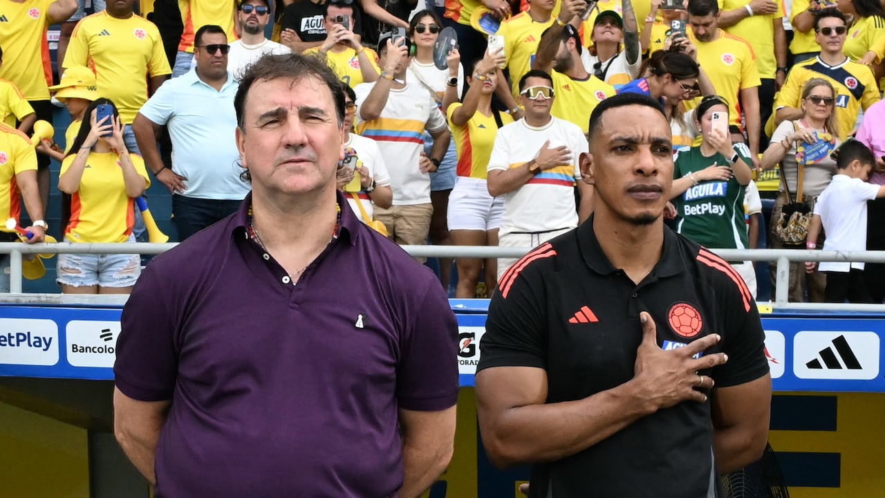 Colombia's Argentine head coach Nestor Lorenzo (L) and assistant coach Luis Amaranto Perea listen to the anthem before the 2026 FIFA World Cup South American qualifiers football match between Colombia and Peru, at the Metropolitano Roberto Melendez stadium in Barranquilla, Colombia, on June 6, 2025. (Photo by Luis ACOSTA / AFP)