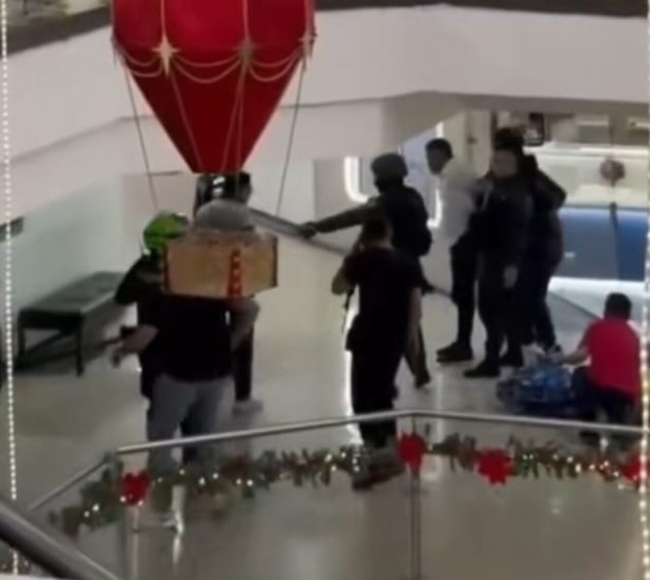 Momentos en que un hombre de camisa blanca y pantalón negro era detenido por la Policía dentro del centro comercial en Bucaramanga.