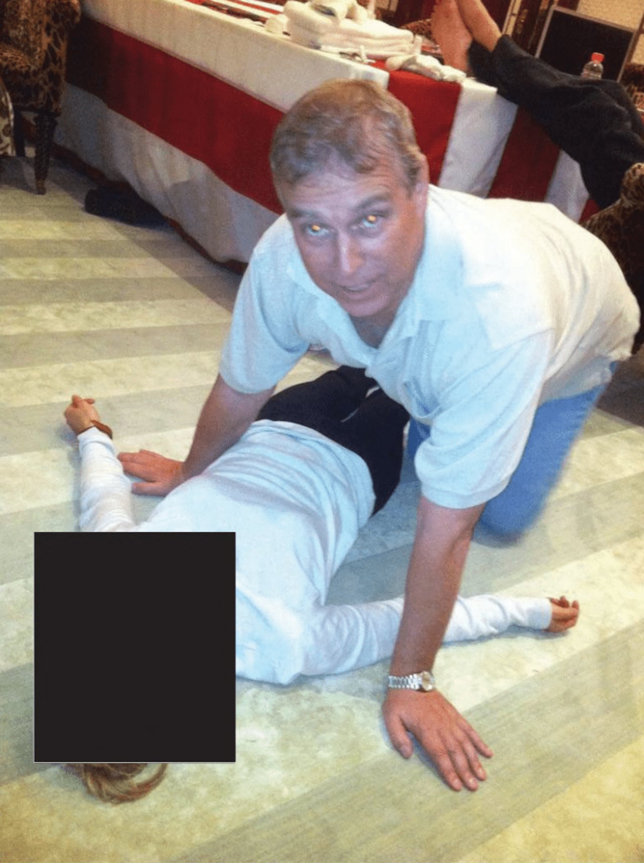This undated photo at an undisclosed location released by the US Justice Department on January 30, 2026 as part of the Jeffrey Epstein files shows British former prince Andrew Mountbatten-Windsor kneeling over a woman lying on the floor. A second Jeffrey Epstein accuser has alleged the late US sex offender sent her to Britain for a sexual encounter with former prince Andrew Mountbatten-Windsor, the BBC reported. A US lawyer for the woman told the broadcaster late January 31, 2026 the alleged encounter occurred at the ousted royal's residence on the Windsor estate, west of London, in 2010 when she was in her 20s. The latest account emerged after the US Justice Department released a huge new batch of documents on the Epstein case, including photographs of Andrew kneeling over a woman lying on the floor. (Photo by Handout / US DEPARTMENT OF JUSTICE / AFP) / RESTRICTED TO EDITORIAL USE - MANDATORY CREDIT "AFP PHOTO / US DEPARTMENT OF JUSTICE" - NO MARKETING NO ADVERTISING CAMPAIGNS - DISTRIBUTED AS A SERVICE TO CLIENTS