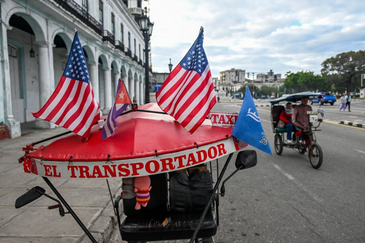 Dos banderas estadounidenses y una cubana ondean en el techo de un triciclo en La Habana, ciudad que enfrenta problemas por la falta de petróleo.