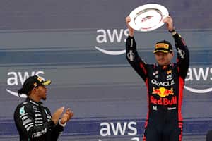 El piloto de Mercedes, Lewis Hamilton, de Gran Bretaña, a la izquierda, aplaude al piloto ganador de Red Bull, Max Verstappen, de Holanda, luego del Gran Premio de España de Fórmula Uno en el circuito Barcelona Catalunya en Montmeló, España, el domingo 4 de junio de 2023. (Foto AP/Joan Monfort )