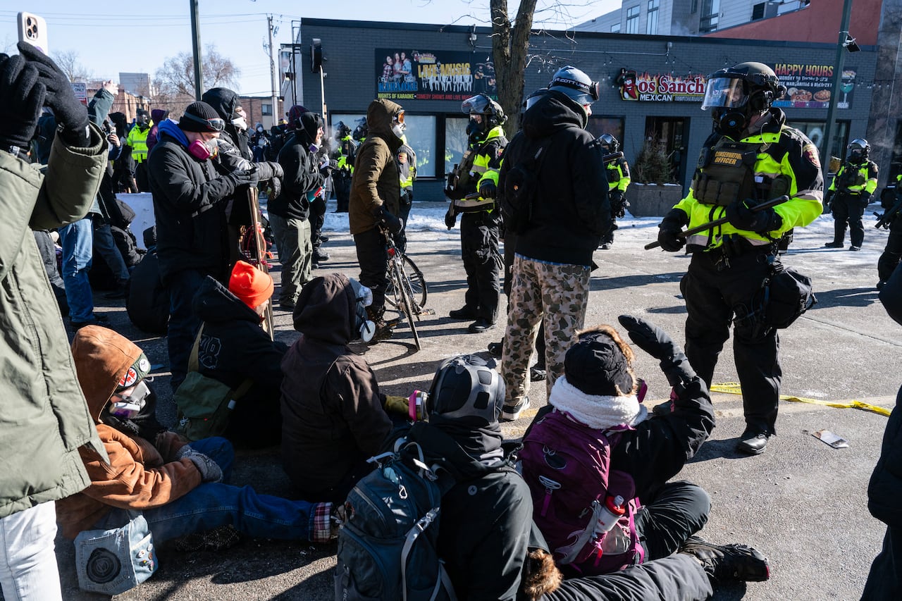 Minnesota Department of Natural Resources Conservation Officers stand guard as demonstrators gather near the site of where state and local authorities say a man was shot and killed by federal agents earlier in the morning in Minneapolis, Minnesota, on January 24, 2026. Federal immigration agents shot dead a man in Minneapolis on Saturday, officials said -- the second fatal shooting of a civilian in the city, sparking fresh protests and outrage from state officials. The death came less than three weeks after US citizen Renee Good was shot and killed by an Immigration and Customs Enforcement officer involved in sweeps to round up undocumented migrants. (Photo by ROBERTO SCHMIDT / AFP)