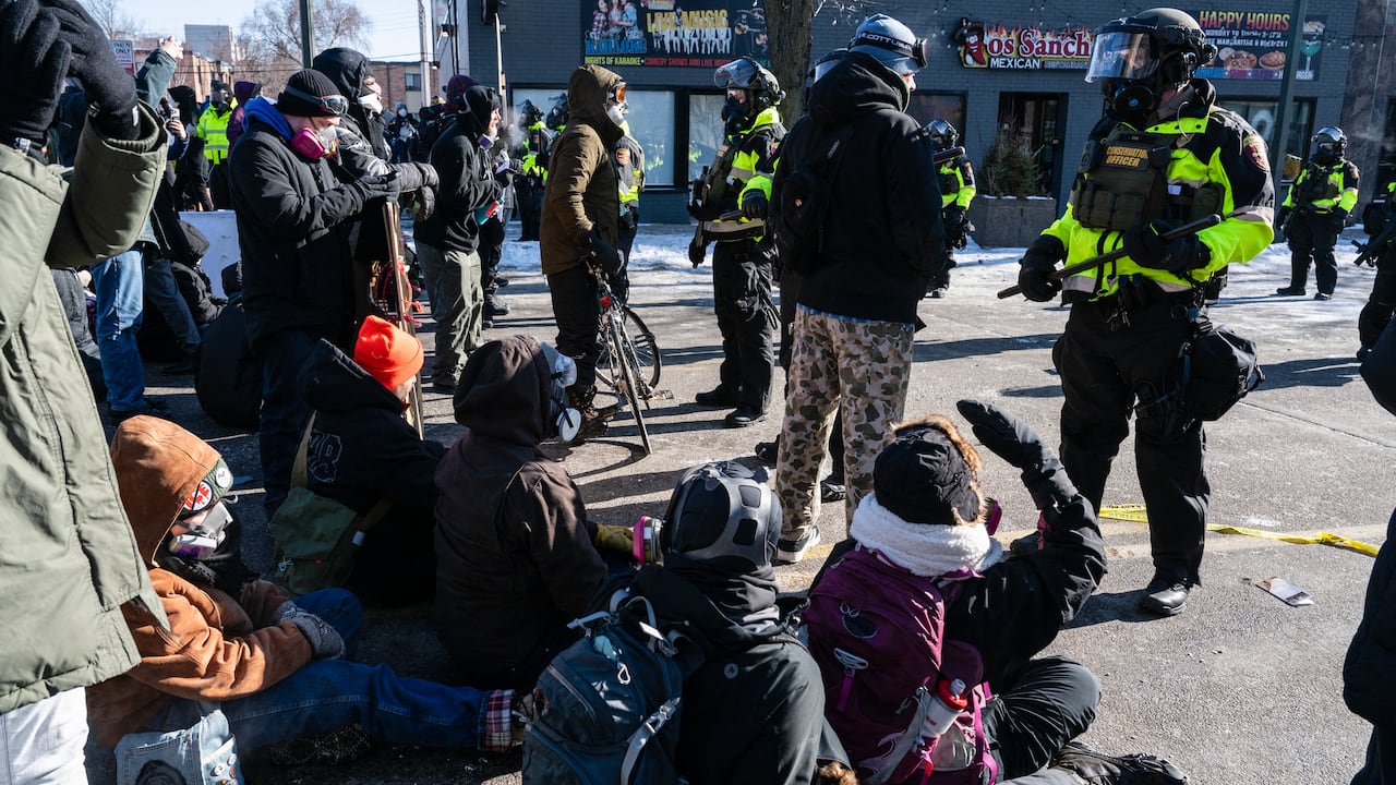 Minnesota Department of Natural Resources Conservation Officers stand guard as demonstrators gather near the site of where state and local authorities say a man was shot and killed by federal agents earlier in the morning in Minneapolis, Minnesota, on January 24, 2026. Federal immigration agents shot dead a man in Minneapolis on Saturday, officials said -- the second fatal shooting of a civilian in the city, sparking fresh protests and outrage from state officials. The death came less than three weeks after US citizen Renee Good was shot and killed by an Immigration and Customs Enforcement officer involved in sweeps to round up undocumented migrants. (Photo by ROBERTO SCHMIDT / AFP)
