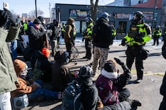 Minnesota Department of Natural Resources Conservation Officers stand guard as demonstrators gather near the site of where state and local authorities say a man was shot and killed by federal agents earlier in the morning in Minneapolis, Minnesota, on January 24, 2026. Federal immigration agents shot dead a man in Minneapolis on Saturday, officials said -- the second fatal shooting of a civilian in the city, sparking fresh protests and outrage from state officials. The death came less than three weeks after US citizen Renee Good was shot and killed by an Immigration and Customs Enforcement officer involved in sweeps to round up undocumented migrants. (Photo by ROBERTO SCHMIDT / AFP)