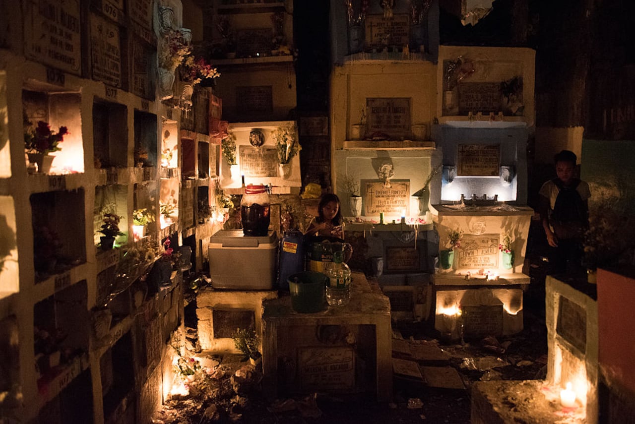 Los filipinos oran durante la celebración del Día de Muertos.