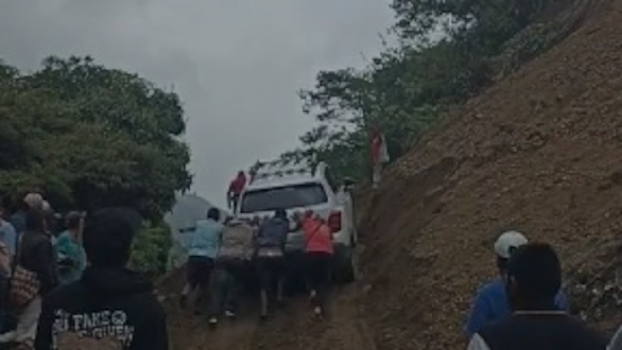 Los comuneros de la zona ayudan a empujar las camionetas para que logre pasar por este punto de la carretera.
