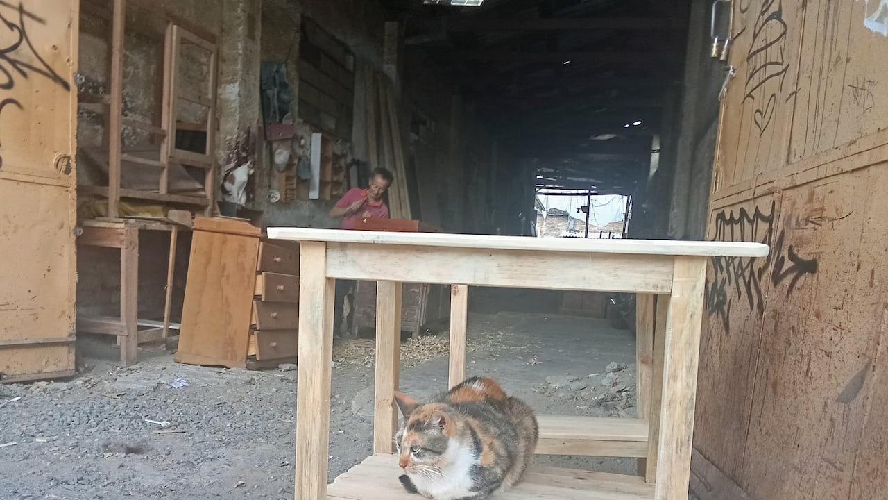 Las sencillas mesas de madera las ubican a la entrada de la carpintería para que la gente la pueda ver y después comprar.