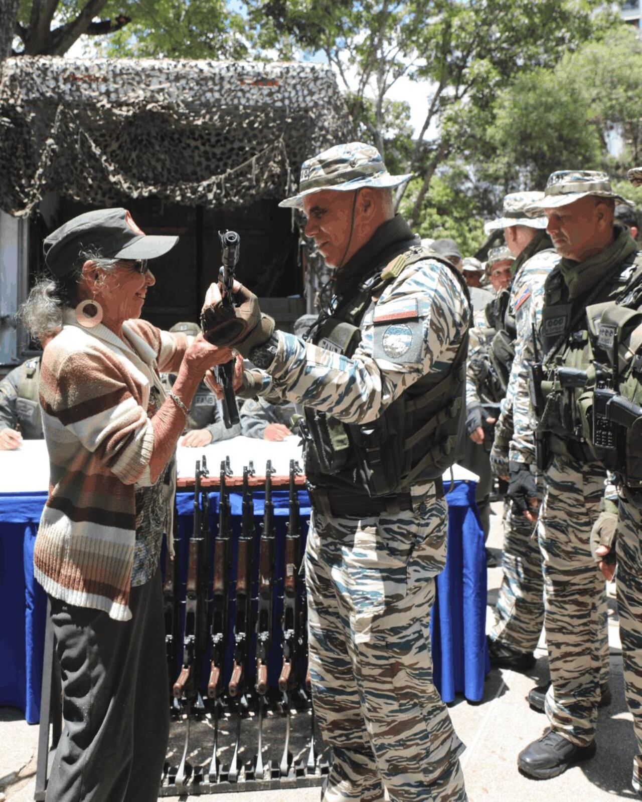 Vladimir Padrino entrega un fusil a una mujer de avanzada edad en Venezuela