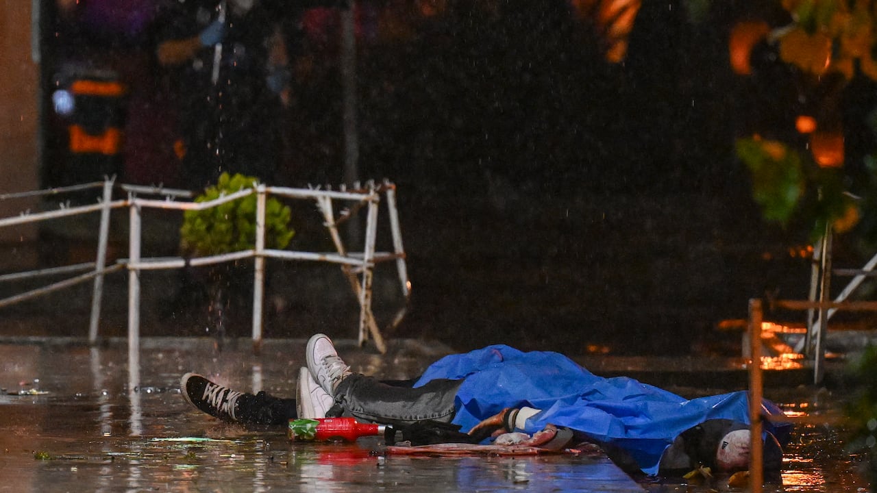 Los cuerpos de dos de las siete personas asesinadas por presuntos pandilleros permanecen afuera de una funeraria en la Ciudad de Guatemala el 30 de julio de 2025. Al menos siete personas murieron y 13 resultaron heridas en un ataque armado durante un funeral en la Ciudad de Guatemala, en un incidente que las autoridades vincularon con disputas entre pandillas, informaron las autoridades. (Foto de JOHAN ORDONEZ / AFP)
