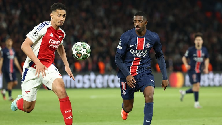 El defensa francés #02 del Arsenal, William Saliba (izq.), lucha por el balón con el delantero francés #10 del Paris Saint-Germain, Ousmane Dembelé.